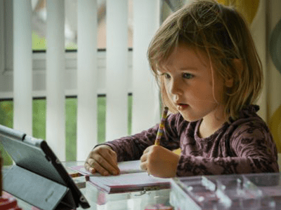 A Young Girl Writing on a Notebook