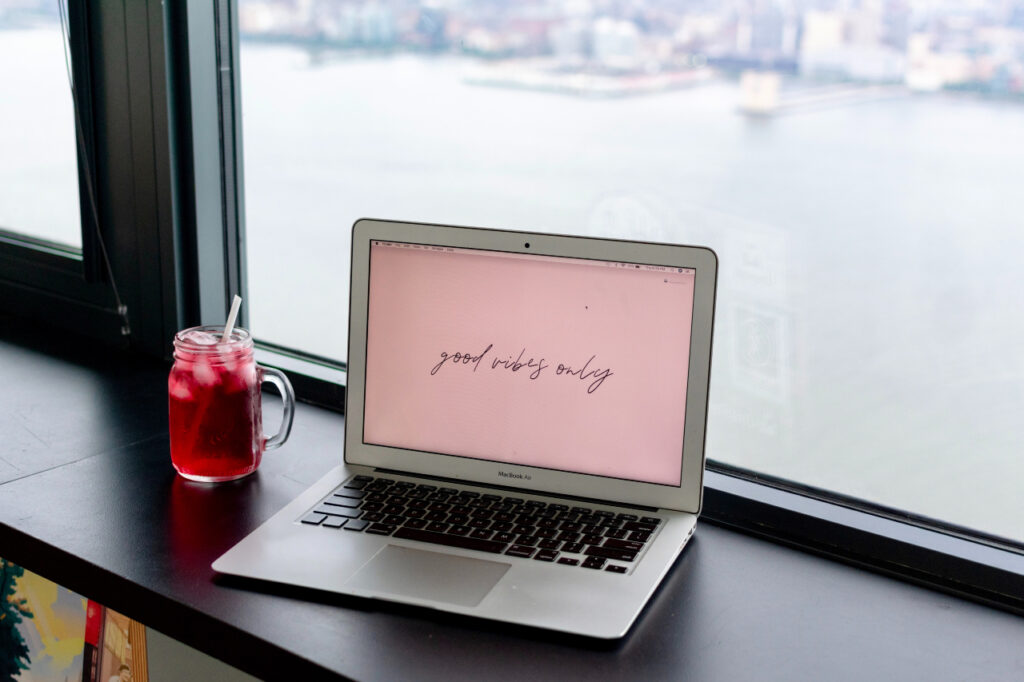 A laptop on a desk overlooks a vibrant city skyline