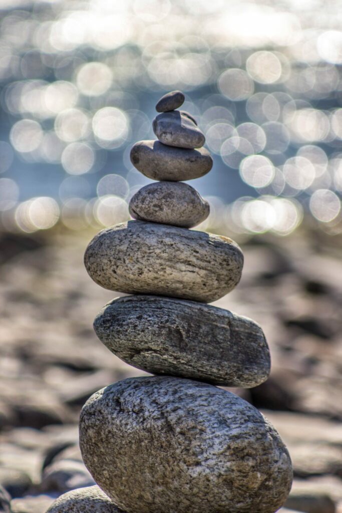 A stack of smooth stones balanced on a beach