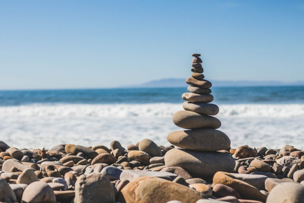 A stack of smooth rocks balanced on a sandy beach