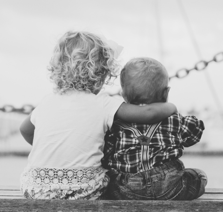 Two children sit on a dock