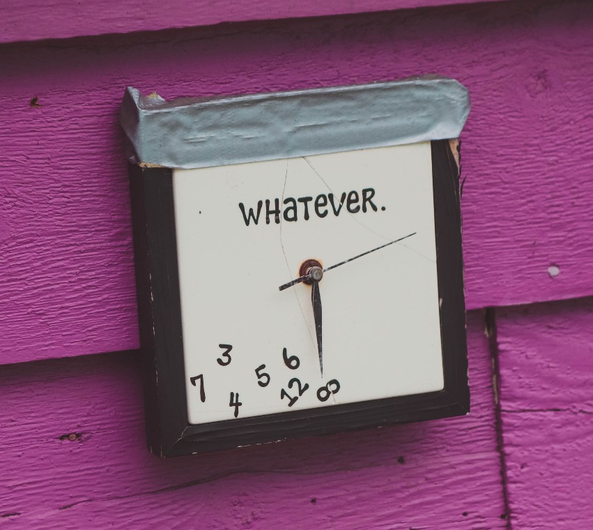 A clock showing the time with various items scattered around it
